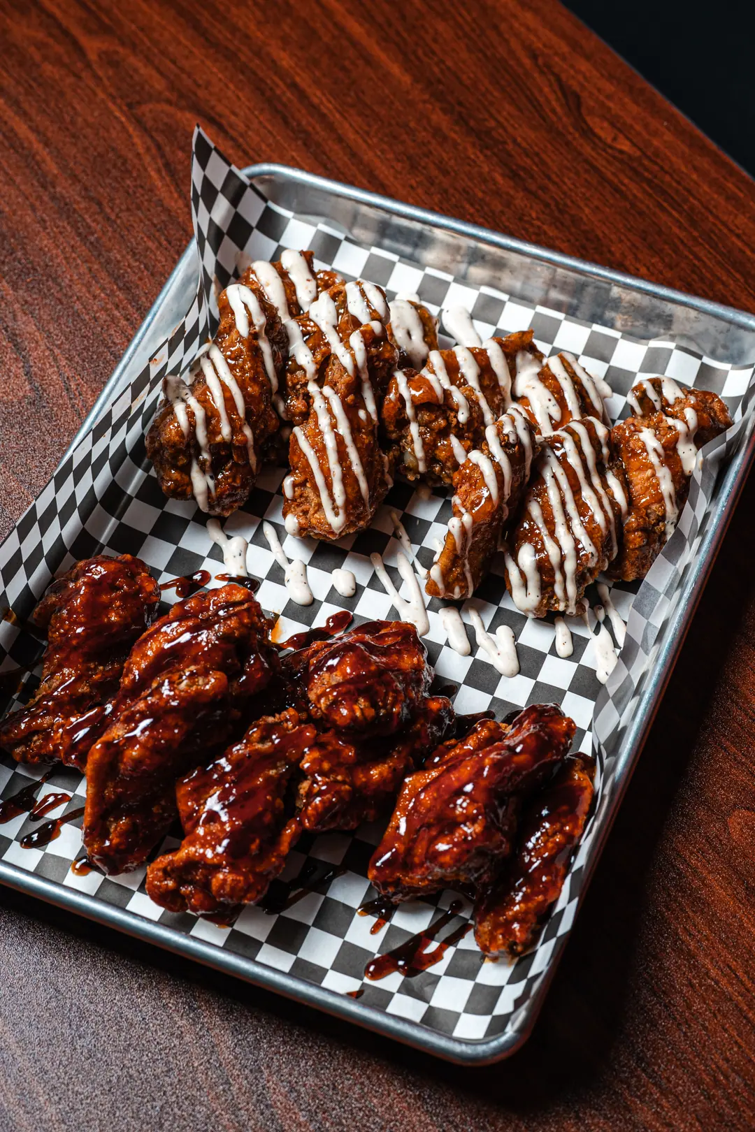 Tray of chicken wings in two flavours, one glazed in sticky sauce and one with a ranch drizzle
